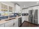 Modern kitchen with white cabinets, stainless steel appliances, quartz countertops and dark backsplash at 3011 Oneida St, Denver, CO 80207