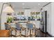 Bright kitchen featuring white cabinetry, stainless steel appliances, and a stylish breakfast bar at 3011 Oneida St, Denver, CO 80207
