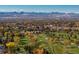 Aerial view of a luxurious home community with a golf course and mountain backdrop at 6 Driver Ln, Littleton, CO 80123