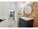 Modern powder room with stone accent wall, decorative round mirror, and sleek black vanity, offering a contemporary feel at 5555 E Briarwood Ave # 2604, Centennial, CO 80122