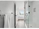 Modern bathroom featuring a glass enclosed shower, gray wood flooring, and bright white walls at 5555 E Briarwood Ave # 2604, Centennial, CO 80122