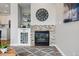 Close-up of a modern fireplace with stone accents, decorative shelving and a round decorative table nearby at 5555 E Briarwood Ave # 2604, Centennial, CO 80122