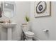 Bright powder room showcasing a pedestal sink, toilet, and decorative art at 3377 S Quartz St, Morrison, CO 80465