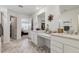 Bright bathroom featuring double vanity, quartz countertops, and gray tile floors, and closet access at 3377 S Quartz St, Morrison, CO 80465