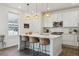 Bright kitchen with white cabinetry, quartz countertops, island with seating, and stainless steel appliances at 3377 S Quartz St, Morrison, CO 80465