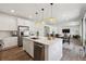 Open kitchen with white cabinets, island with sink, and stainless steel appliances flowing into the dining area at 3377 S Quartz St, Morrison, CO 80465