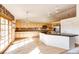 Bright kitchen featuring wood cabinets, granite countertops, an island, tile backsplash, stainless steel appliances, and a sliding glass door at 23612 Glenmoor Dr, Parker, CO 80138