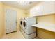 Well-equipped laundry area with washer, dryer, built-in cabinets and countertop for folding at 23612 Glenmoor Dr, Parker, CO 80138