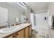 Bathroom featuring double sinks, a shower with tub, and sleek fixtures, blending functionality with modern design at 277 Jewel St, Brighton, CO 80603