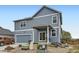 Exterior shot of the two-story house showcasing the garage and backyard patio on a gravel lot at 277 Jewel St, Brighton, CO 80603