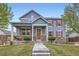 Charming two-story blue home with a welcoming front porch and meticulously maintained lawn at 277 Jewel St, Brighton, CO 80603