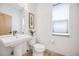 Stylish powder room with modern fixtures, pedestal sink and natural light at 3008 Blake St, Denver, CO 80205