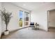 Minimalist sitting room with a plant near the windows, chair, and small table at 3008 Blake St, Denver, CO 80205
