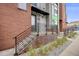 Townhouse entrance featuring brick facade, wrought iron railings, covered entryway and modern design elements at 3008 Blake St, Denver, CO 80205