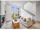 Inviting living room featuring a modern fireplace, large windows, neutral-toned furniture, and open staircase at 3008 Blake St, Denver, CO 80205