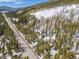 Distant aerial of a wooden home next to a snowy hill and a highway at 6087 Highway 9, Breckenridge, CO 80424