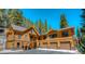 Stunning exterior showcasing the home's wood design, three-car garage, and a beautiful forested surrounding landscape at 6087 Highway 9, Breckenridge, CO 80424