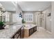 This bathroom features dual sinks, granite countertops, soaking tub, and a glass-enclosed shower at 12678 Fisher Ln, Englewood, CO 80112