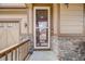 Welcoming front porch with stone accents, leading to a screened front door and attached two-car garage at 12678 Fisher Ln, Englewood, CO 80112