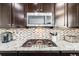 Close up of stainless steel appliances, granite countertops, and mosaic backsplash in the kitchen at 12678 Fisher Ln, Englewood, CO 80112