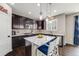 Dark wooden cabinetry and white countertops in this kitchen with barstool seating at the island at 12678 Fisher Ln, Englewood, CO 80112