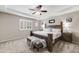 A spacious main bedroom with tray ceilings, a ceiling fan, carpeted floors, and shuttered windows at 12678 Fisher Ln, Englewood, CO 80112
