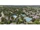 Aerial shot featuring a community pool and tennis courts surrounded by neighborhood homes and lush trees at 7099 Cerney Cir, Castle Pines, CO 80108
