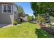 A home's backyard features a green lawn, trees, and a view of the home with a deck at 7099 Cerney Cir, Castle Pines, CO 80108