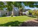A home's green backyard with mature trees, an outdoor trampoline, and a wooden deck at 7099 Cerney Cir, Castle Pines, CO 80108