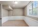Finished basement area featuring wainscotting, neutral colors, carpet, and a window for natural light at 7099 Cerney Cir, Castle Pines, CO 80108