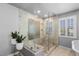 Luxurious bathroom featuring a spacious glass shower with stone accents and tiled flooring at 7099 Cerney Cir, Castle Pines, CO 80108