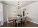 Dining room featuring a solid wood table, elegant chandelier, and contemporary decor in a neutral color palette at 7099 Cerney Cir, Castle Pines, CO 80108