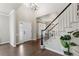 Bright foyer with hardwood floors, soaring ceiling, a staircase with white railings, and an elegant chandelier at 7099 Cerney Cir, Castle Pines, CO 80108