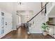 Welcoming foyer with hardwood floors, staircase with black and white railings, and dining room in the background at 7099 Cerney Cir, Castle Pines, CO 80108