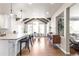 Bright kitchen with white cabinetry, wooden beams, large island, and open view to dining and living areas at 7099 Cerney Cir, Castle Pines, CO 80108