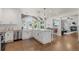 Stylish kitchen with a central island, farmhouse sink, white cabinets, and open layout to adjacent living spaces at 7099 Cerney Cir, Castle Pines, CO 80108