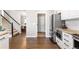 Modern kitchen with hardwood floors, stainless steel appliances, and open layout to dining area and staircase at 7099 Cerney Cir, Castle Pines, CO 80108