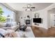 Bright living room featuring a stone fireplace, TV, and large window views to the outdoors at 7099 Cerney Cir, Castle Pines, CO 80108