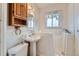 Bright bathroom featuring a walk-in tub, pedestal sink, and wooden cabinet at 1931 Dayton St, Aurora, CO 80010