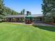 Charming backyard with covered patio area and spacious green lawn at 32453 Upper Bear Creek Rd, Evergreen, CO 80439