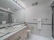 Bathroom with white tile, shower with glass door, and updated vanity at 32453 Upper Bear Creek Rd, Evergreen, CO 80439