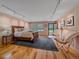 Light-filled bedroom with wood paneled walls, track lighting, and hardwood floors at 32453 Upper Bear Creek Rd, Evergreen, CO 80439