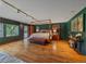 Large bedroom with hardwood floors, canopy bed, and bright windows at 32453 Upper Bear Creek Rd, Evergreen, CO 80439