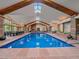 Indoor swimming pool with skylights, exposed beams and an adjacent dining area at 32453 Upper Bear Creek Rd, Evergreen, CO 80439