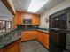 Wet bar with wood cabinets, granite counters, stainless sink, and modern appliances at 32453 Upper Bear Creek Rd, Evergreen, CO 80439