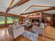 Spacious living room features a brick fireplace, wood floors, wood paneled walls, and beamed vaulted ceiling at 32453 Upper Bear Creek Rd, Evergreen, CO 80439