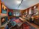 Cozy living room with a fireplace, rich red rug, and views of a snow-covered landscape at 32453 Upper Bear Creek Rd, Evergreen, CO 80439