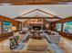 Bright living room features wood floors, a brick fireplace, vaulted ceiling, and large windows at 32453 Upper Bear Creek Rd, Evergreen, CO 80439