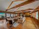 Large living room with wood floors, wood paneled walls, vaulted ceiling, and stone fireplace at 32453 Upper Bear Creek Rd, Evergreen, CO 80439
