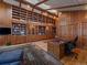 Spacious home office with wood-paneled walls, a ladder to reach top bookshelves, and a plush rug at 32453 Upper Bear Creek Rd, Evergreen, CO 80439